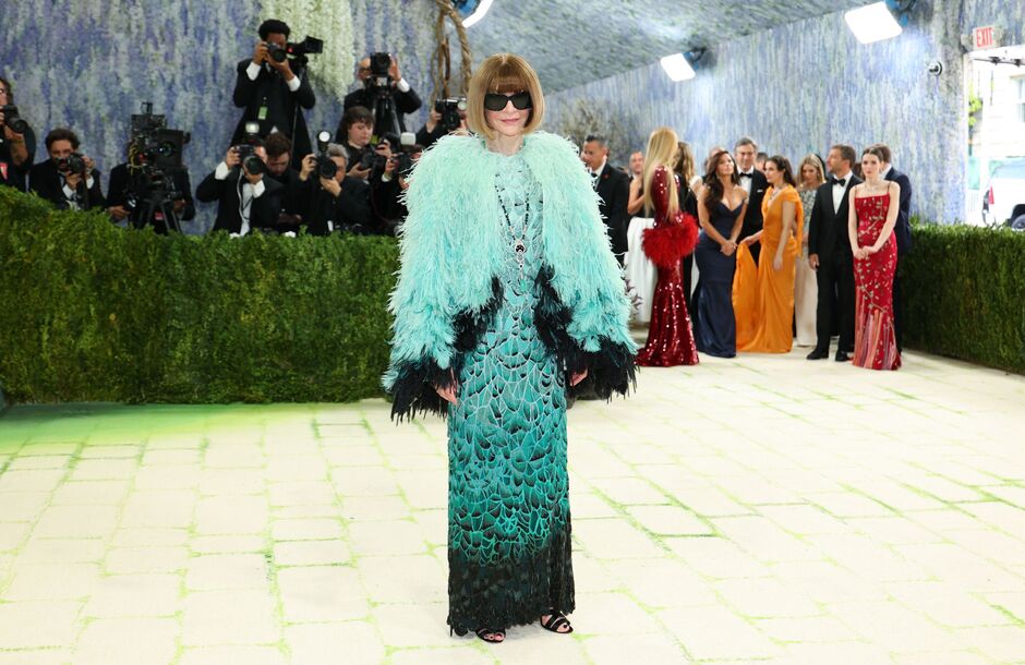 Katy Perry (AP News) - THEWILL NEWS MEDIA Celebrity on a red carpet wearing a turquoise feathered coat over a teal gown, posing for photographers.
