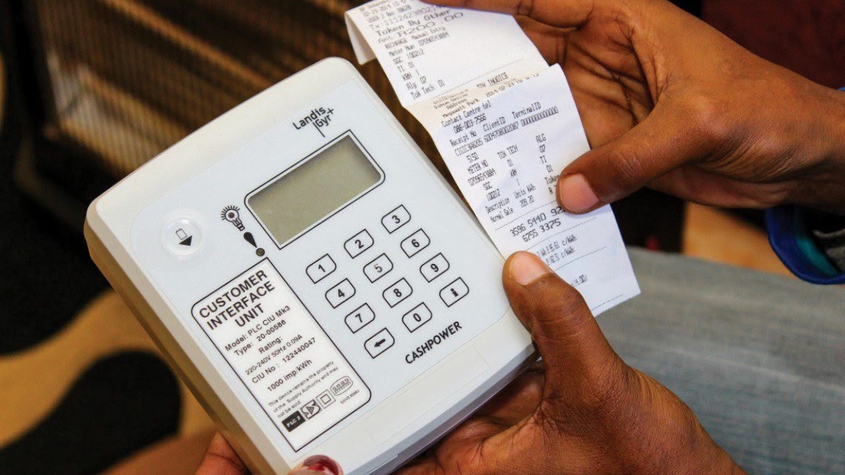 A representation of electricity distribution infrastructure in Nigeria's evolving power sector. - THEWILL NEWS MEDIA A handheld cash register-like device labeled'Customer Interface Unit' with a numeric keypad and a printed receipt being held by hands nearby.