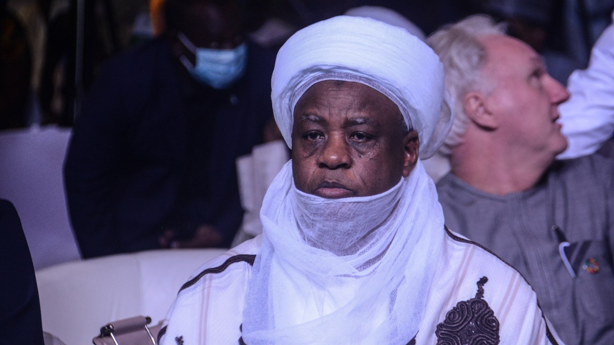 The Sultan of Sokoto Muhammadu Saad Abubakar - THEWILL NEWS MEDIA Man wearing a white turban and face veil seated in an audience at an event