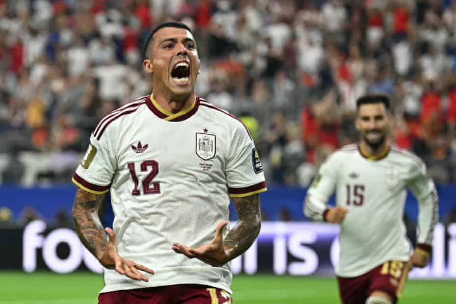 Pedro Porro celebrates goal - THEWILL NEWS MEDIA Soccer player wearing number 12 jersey shouts in celebration on the field, with teammate number 15 approaching in the background.