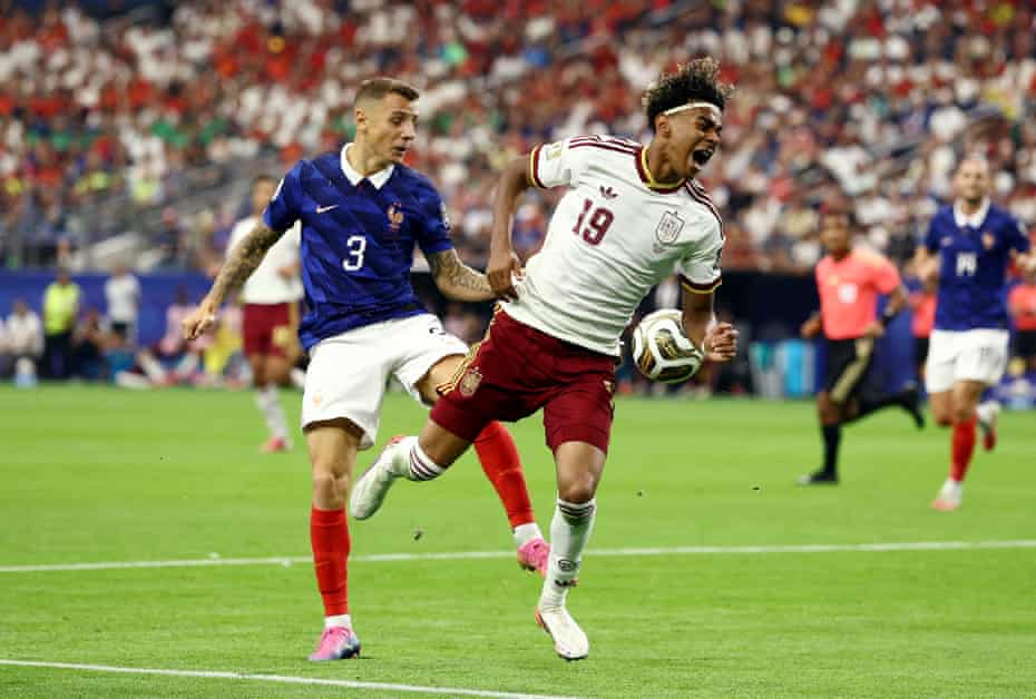 Lucas Digne trips Lamine Yamal in the 18-yard box - THEWILL NEWS MEDIA Soccer action: a white-jersey player with maroon shorts controls the ball as a blue-jersey defender closes in.