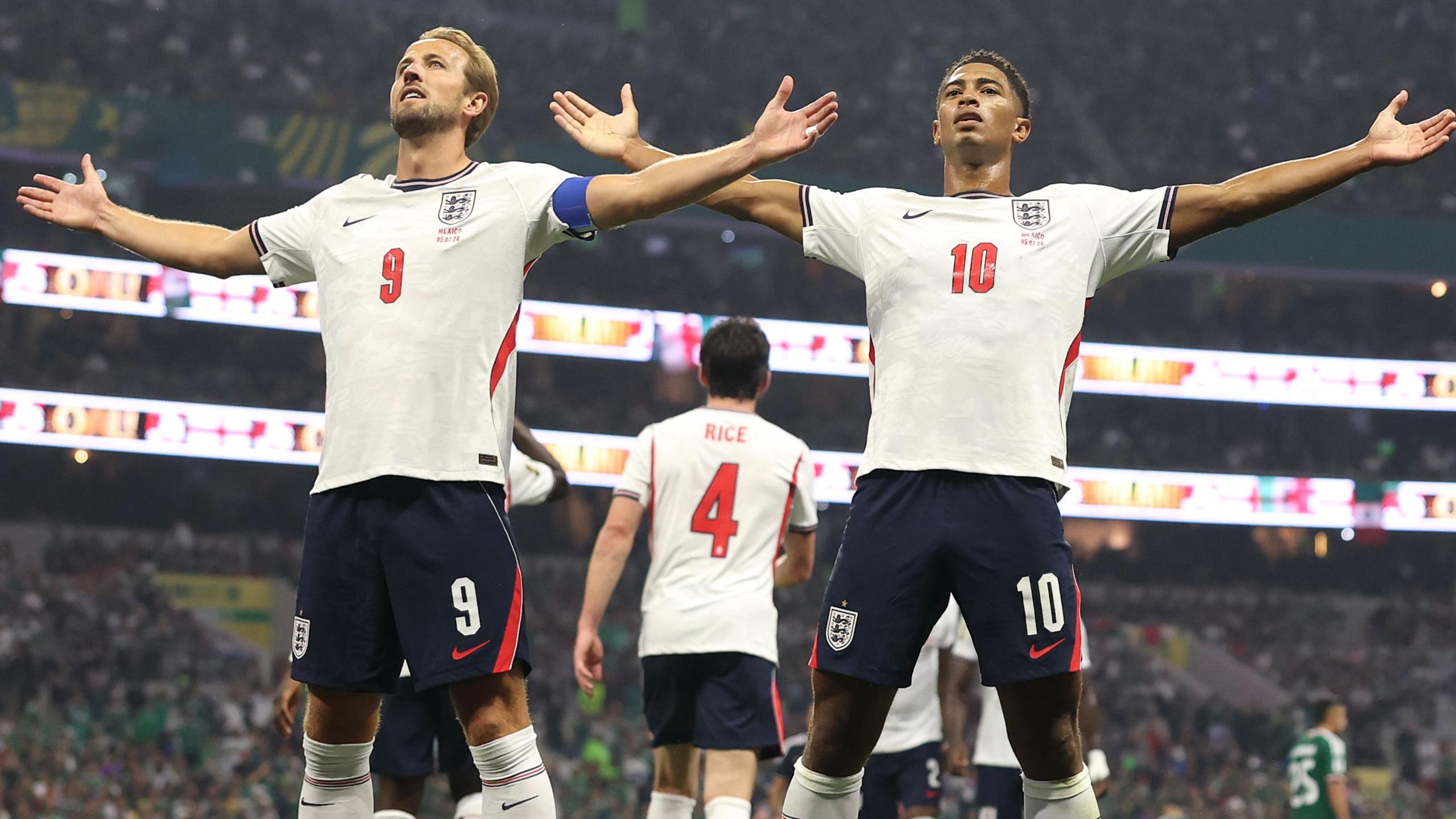 Jude Bellingham and Harry Kane celebrate a goal at the World Cup 2026 - THEWILL NEWS MEDIA England footballers celebrate with arms outstretched, wearing white jerseys with numbers 9 and 10 during a match.