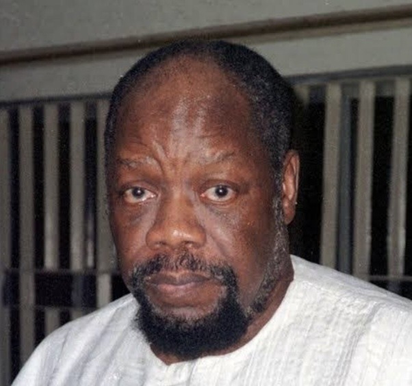 Close-up portrait of a middle-aged man with a short beard, wearing a light-colored traditional shirt and looking at the camera.