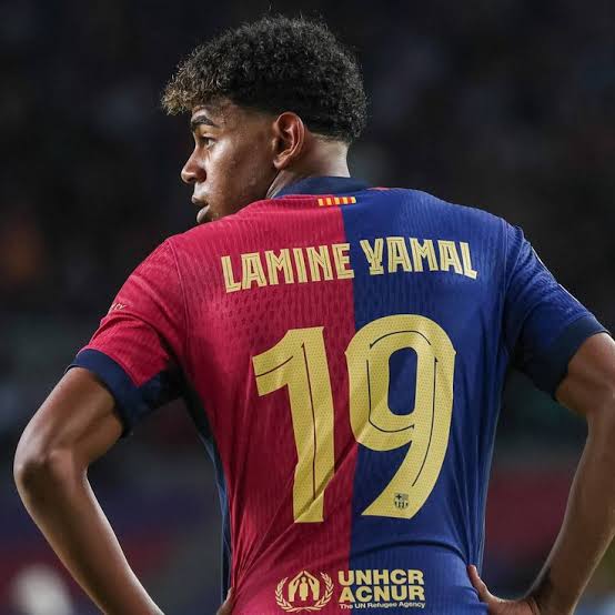 Before inheriting Barcelona's iconic No. 10 shirt, both Lionel Messi and Lamine Yamal wore the club's No. 19, a remarkable parallel in two extraordinary careers/Photo credit: Getty image - THEWILL NEWS MEDIA Back view of footballer Lamine Yamal wearing a red-and-blue jersey with the number 19 on his back.