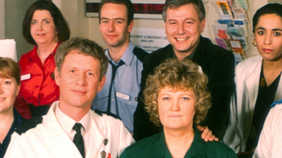 Group of healthcare workers posing for a photo in a clinic, with a man in a white coat at the front.