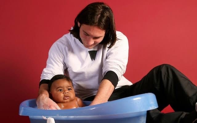 From a UNICEF charity photoshoot in 2007 to the 2026 FIFA World Cup final, Lionel Messi and Lamine Yamal's extraordinary connection has become one of football's most captivating stories. (Photo Credit: Getty Images/FC Barcelona/Joan Monfort) - THEWILL NEWS MEDIA Parent bathing a baby in a blue plastic tub on the floor, against a red wall.