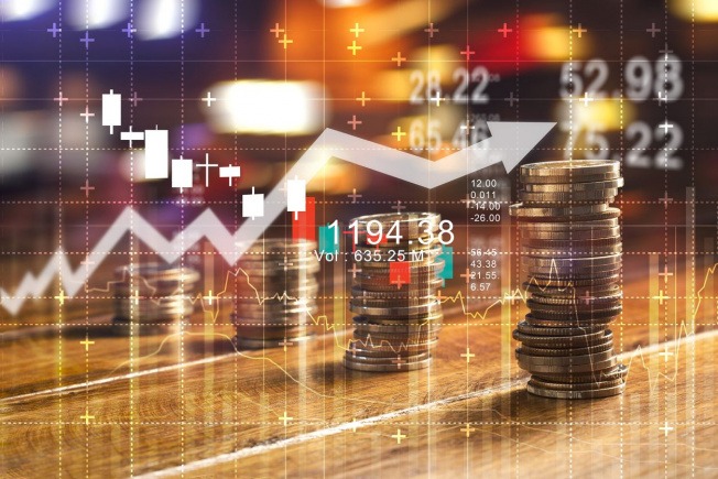 Investments ( credit Money Marketing) - THEWILL NEWS MEDIA Stacks of coins beside a glowing stock chart and data overlay, illustrating financial growth and investment trends.
