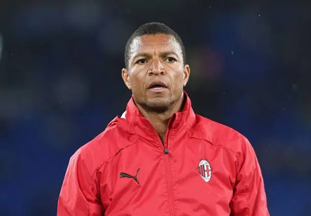 DIDA - THEWILL NEWS MEDIA Portrait of a man wearing a red AC Milan jacket with the club crest, standing outdoors and looking ahead.