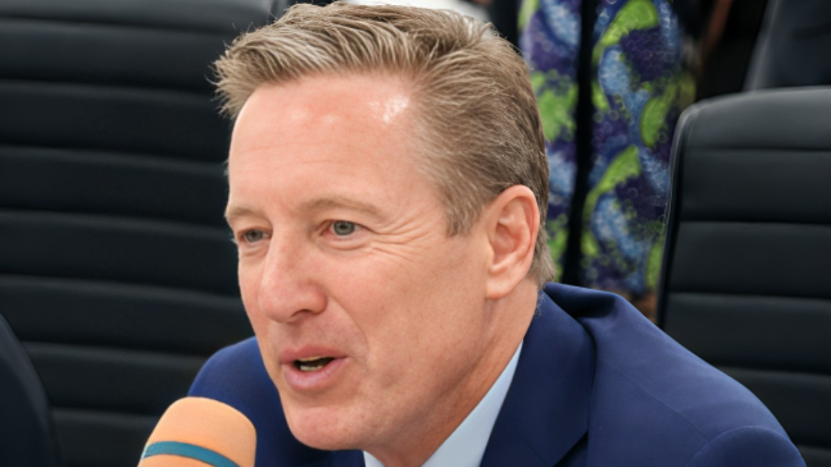 David Bird - THEWILL NEWS MEDIA Man in a blue suit speaks into an orange microphone at a press conference or media event.