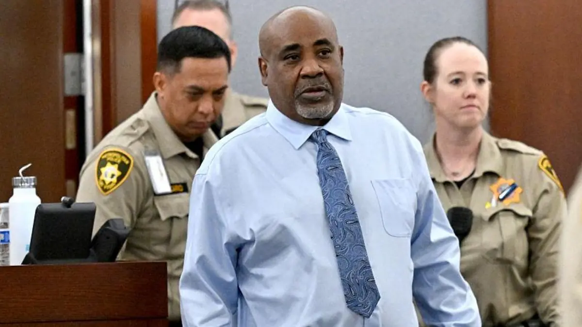 Duane Keffe D Davis appears in court - THEWILL NEWS MEDIA Man in light blue dress shirt and patterned blue tie walking in a courtroom with security guards in the background.