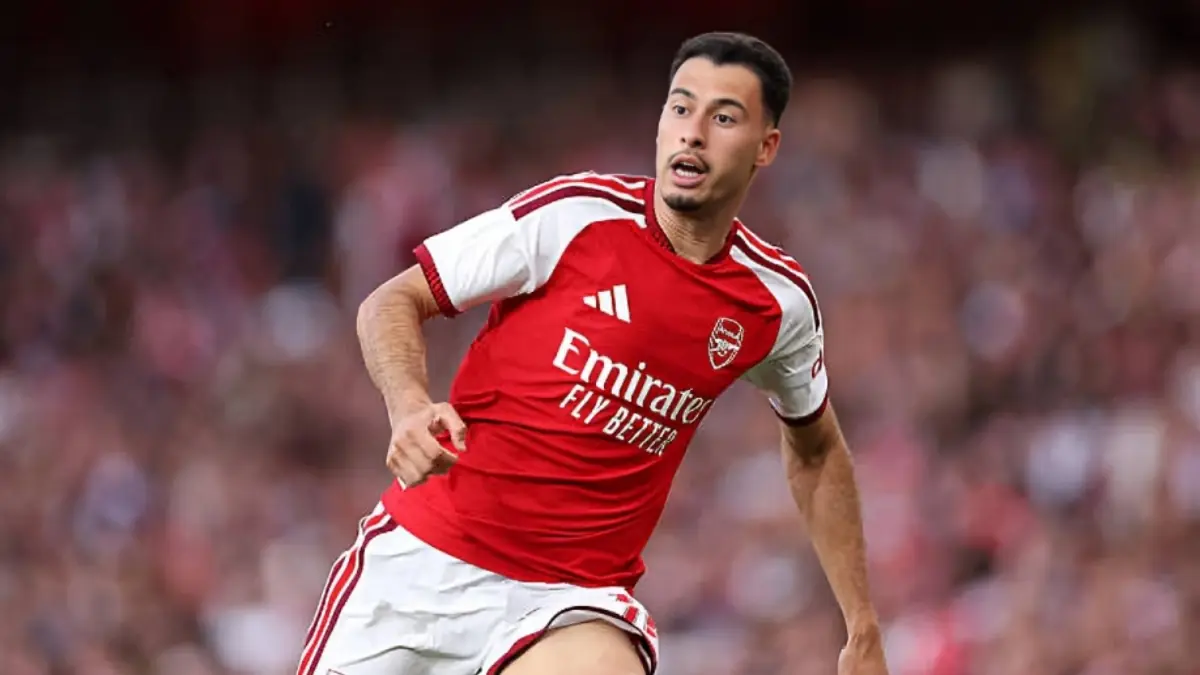 Gabriel Martinelli - THEWILL NEWS MEDIA Arsenal footballer in a red jersey running on the pitch during a match, with a blurred crowd in the background.