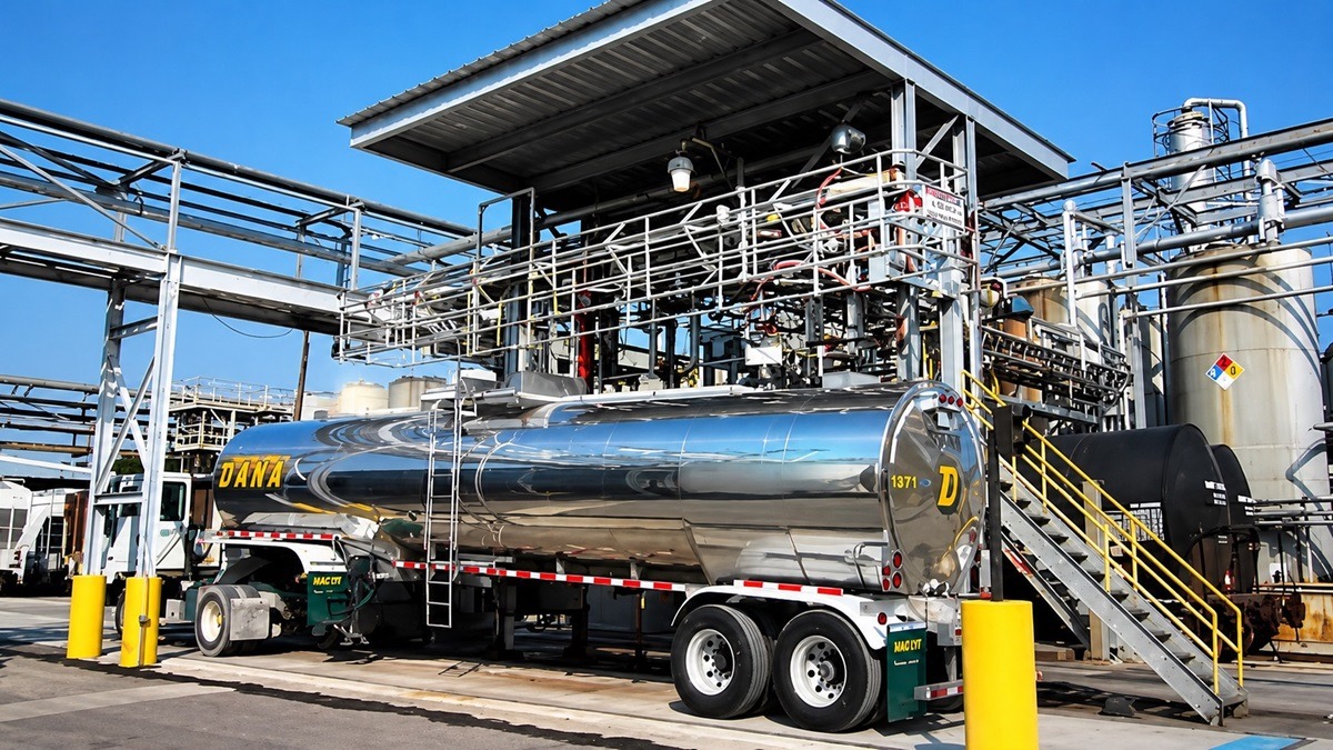 Jet fuel 1 - THEWILL NEWS MEDIA Polished stainless steel tanker trailer labeled DANA at an industrial plant with metal walkways and piping.