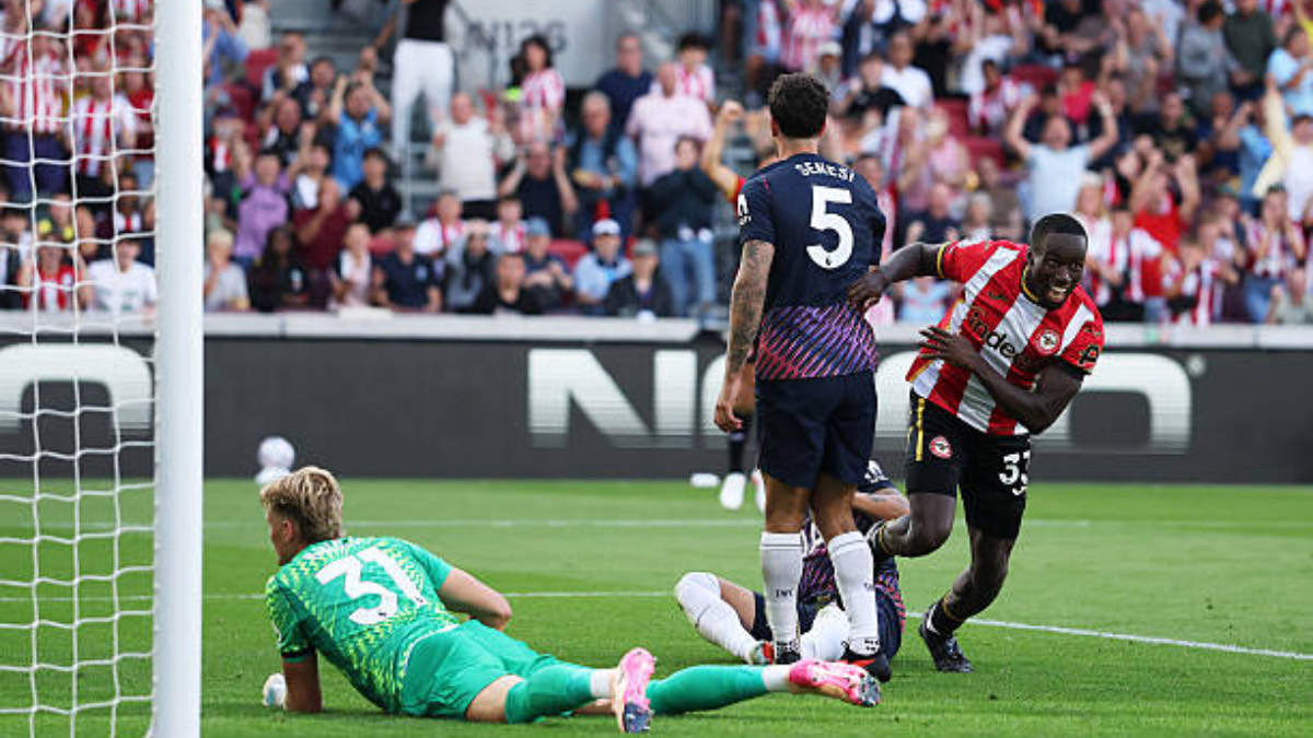 Michael Kayode of Brentford celebrates - THEWILL NEWS MEDIA Soccer match image: goalkeeper in green dives near the goal as players contest the ball and a cheering crowd watches from the stands.