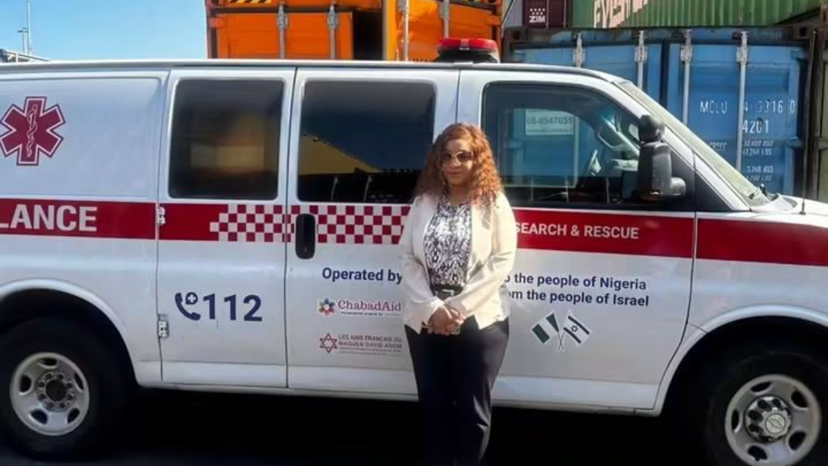 Nigerian Ambassador to Israel Nkechi Ufochukwu - THEWILL NEWS MEDIA Woman standing beside a white ambulance with a red stripe and'Search & Rescue' text, logos on the door.