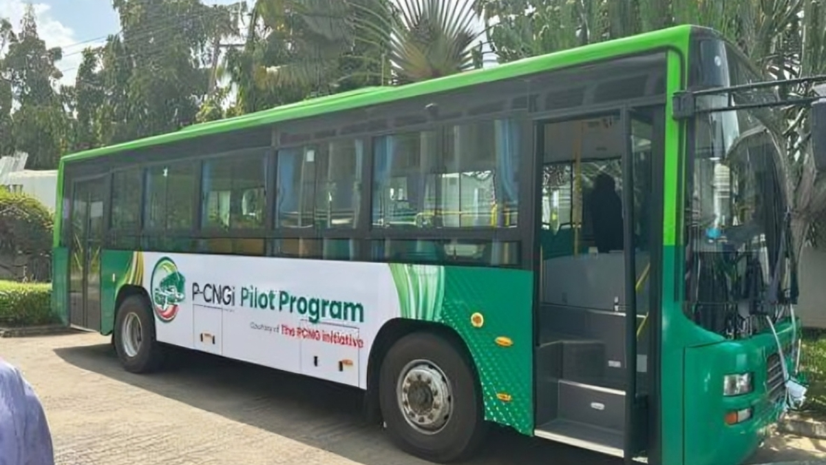 Presidential CNG Initiative PCNGI mass transit bus - THEWILL NEWS MEDIA Green city bus parked with its front door open, displaying a banner that reads'PCNGI Pilot Program' along the side.