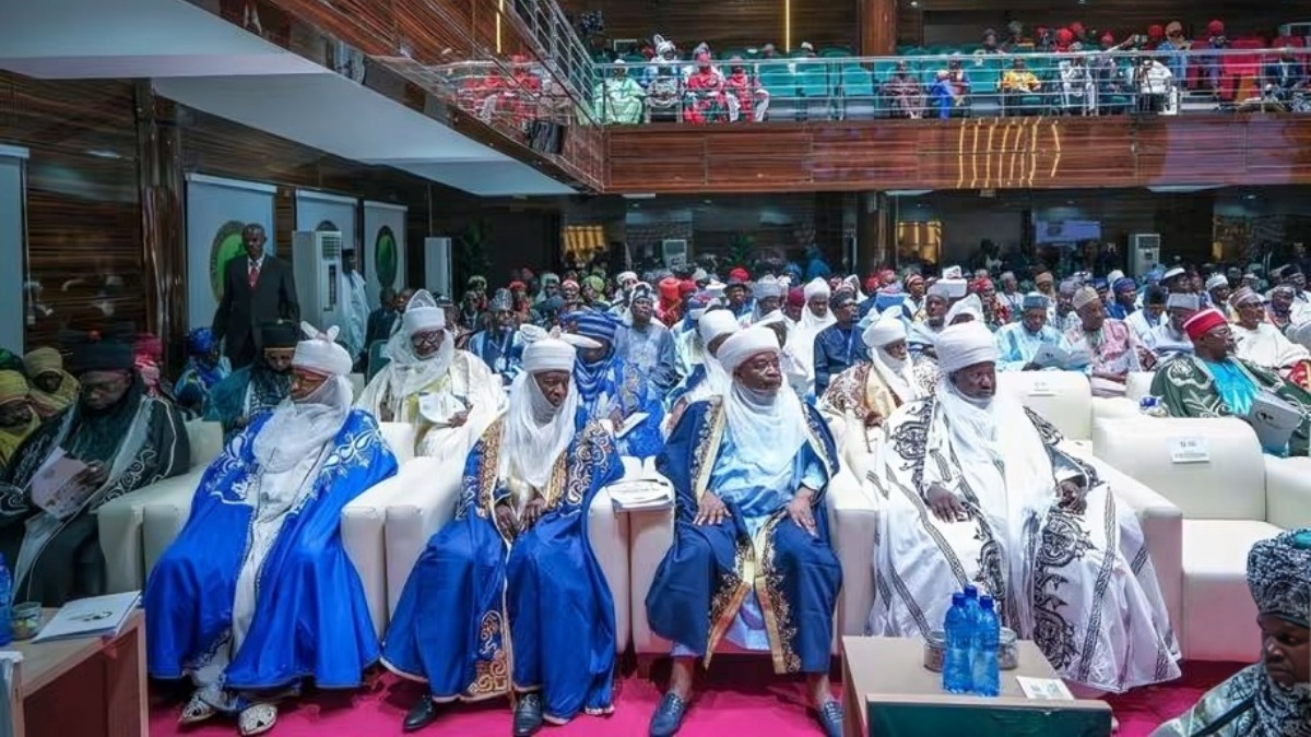 Traditional rulers religious leaders government officials - THEWILL NEWS MEDIA Group of predominantly men in white and blue traditional robes seated on white couches at a formal ceremony, with a large audience in the background.