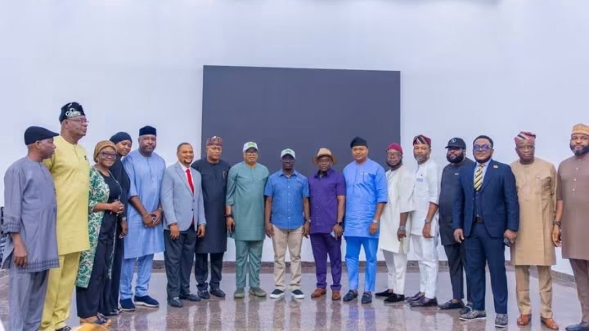 new leadership and members of the Edo State House of Assembly - THEWILL NEWS MEDIA Group of adults in colorful traditional attire posing in a line for a portrait indoors.