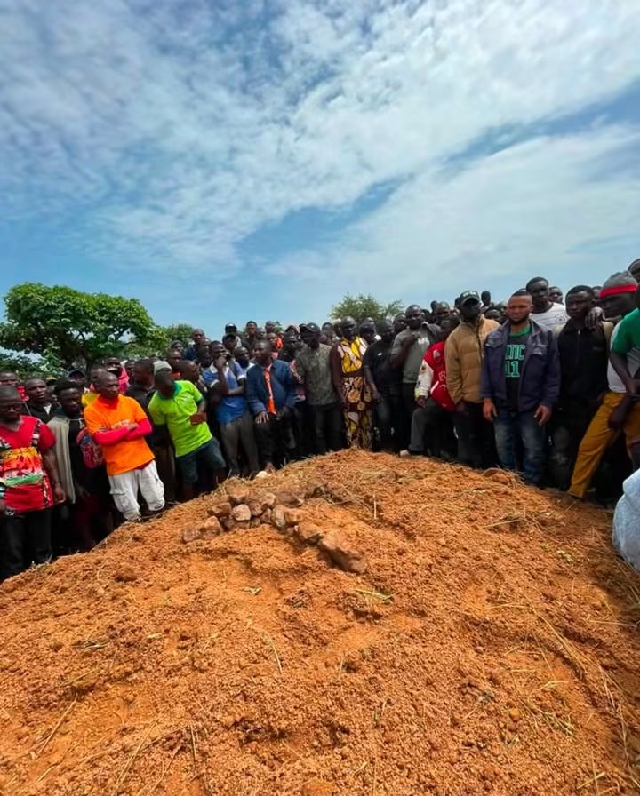 victims of gunmen attacks in Mangu Community - THEWILL NEWS MEDIA A large group of people gathered around a freshly dug grave mound outdoors on a sunny day.