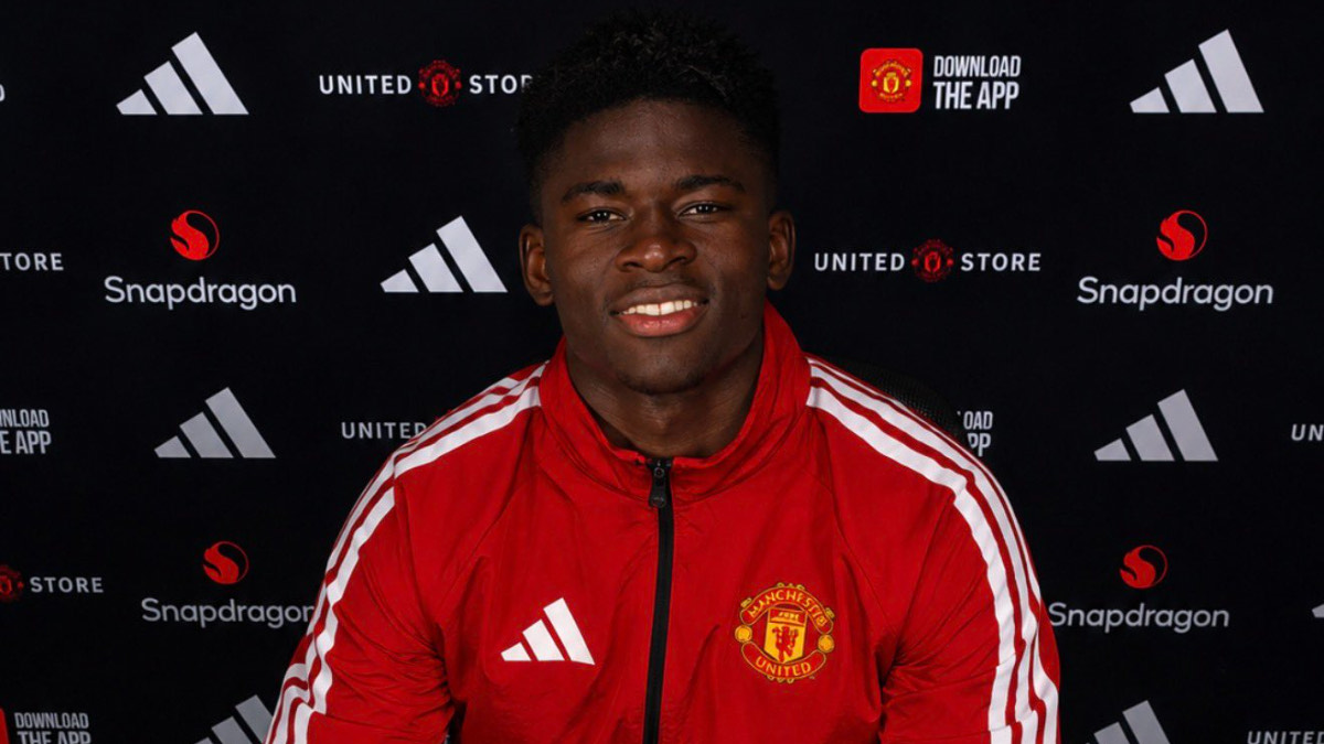 Carlos Baleba - THEWILL NEWS MEDIA Young man in a red Manchester United tracksuit jacket posing in front of a branded backdrop with logos (Adidas, Snapdragon).