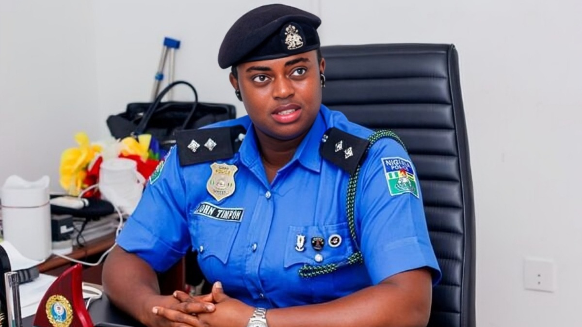 DSP Timfon John - THEWILL NEWS MEDIA Female Nigerian police officer in a blue uniform and beret sits at a desk in an office, looking to the side.