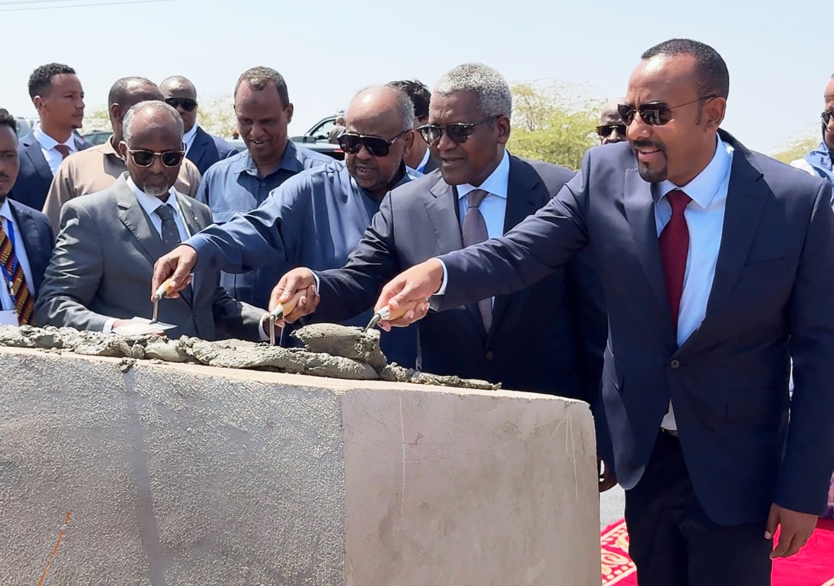 Ethiopia Djibouti leaders back Dangote Oil and Gas - THEWILL NEWS MEDIA Dignitaries in suits use trowels to smooth fresh concrete on a low wall at a construction ceremony.