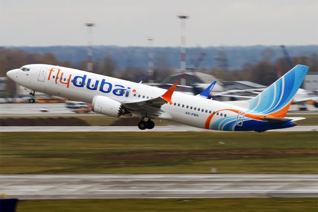 Flydubai aircraft - THEWILL NEWS MEDIA FlyDubai passenger jet taking off from the runway, landing gear extended, white with orange and blue livery.