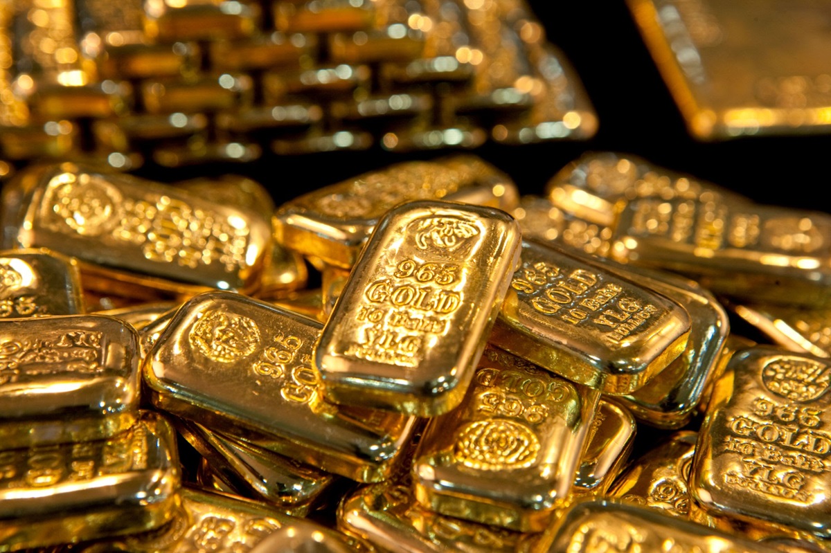 Golden Wealth in Glowing Stacks The Power of Precious Metal Investments - THEWILL NEWS MEDIA Close-up of shiny gold bullion bars stacked in a pile, many with'999 GOLD' markings and decorative seals visible.