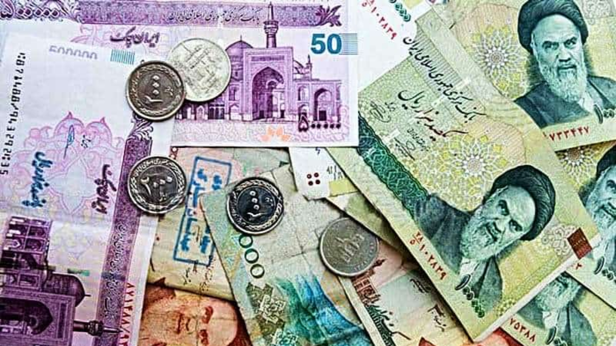 Iranian Rial - THEWILL NEWS MEDIA Iranian currency notes and coins scattered on a surface, showing colorful rial banknotes and metal coins