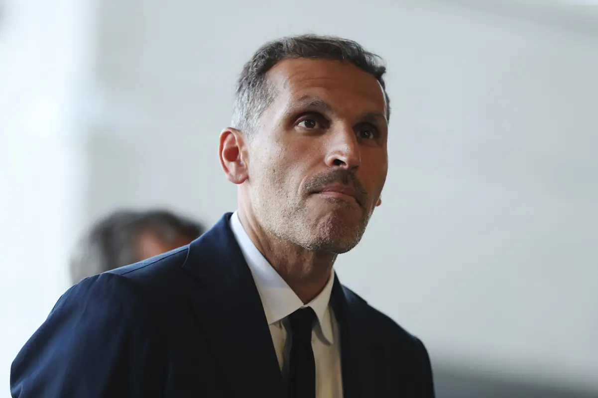 Manchester City FC v Al-Hilal Round Of 16 - FIFA Club World Cup 2025 - THEWILL NEWS MEDIA Man in a navy suit and black tie looks upward in a bright indoor setting, thoughtful expression.