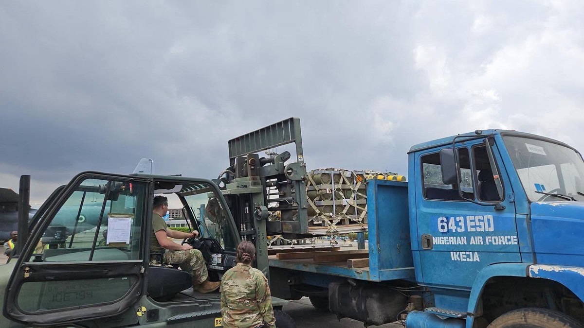 Nigerian Air Force with the U S Air Force - THEWILL NEWS MEDIA Military personnel operate a forklift to load a palletized cargo onto a blue Nigerian Air Force truck under a cloudy sky
