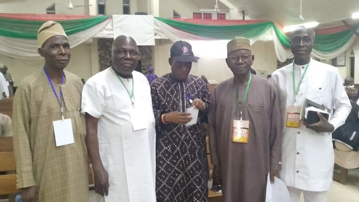 Northern Christian Elders - THEWILL NEWS MEDIA Five men in traditional Nigerian attire pose for a group photo at an event, wearing lanyards and badges in a decorated hall.