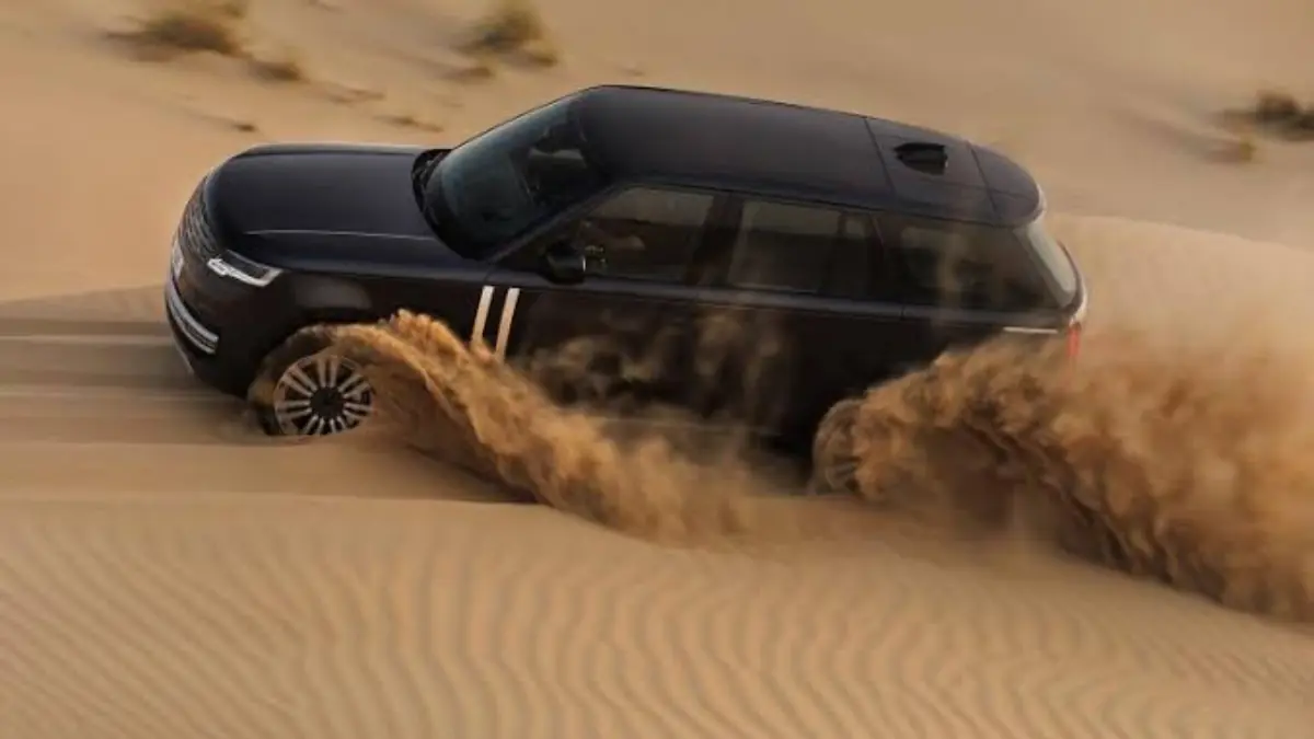 Range Rover - THEWILL NEWS MEDIA Black SUV speeding across desert dunes, kicking up a cloud of sand behind its wheels