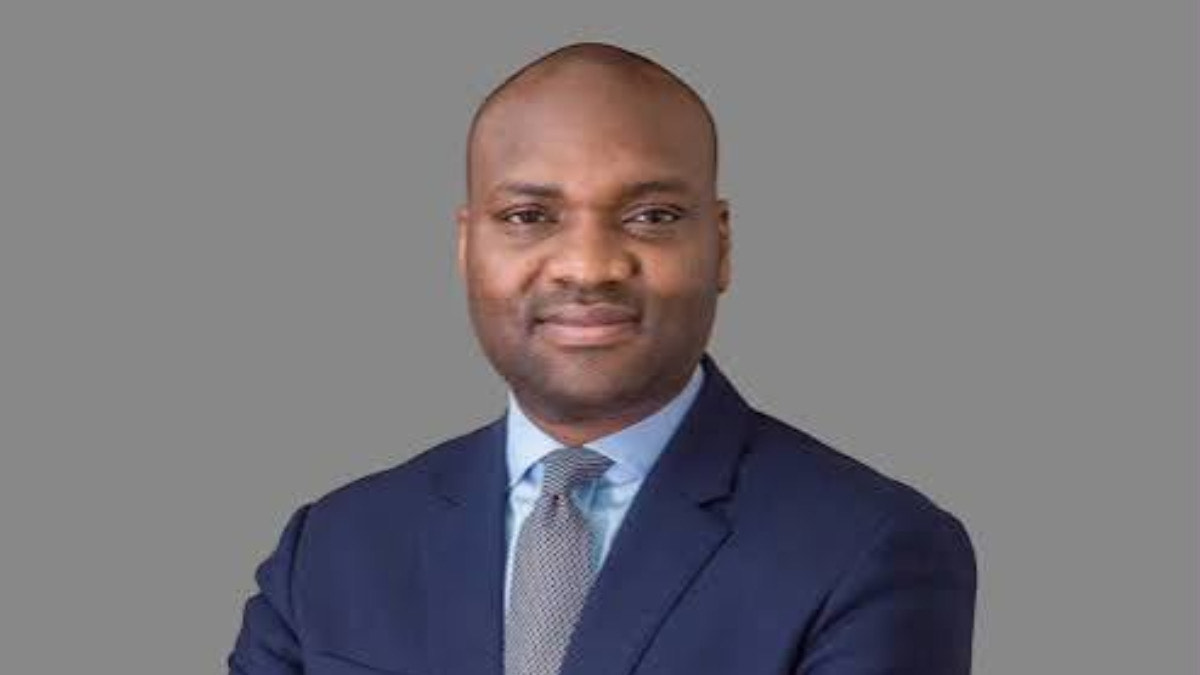Abdu Mukhtar - THEWILL NEWS MEDIA Head-and-shoulders portrait of a man in a navy suit, light blue shirt, and gray tie against a neutral gray background (professional headshot).