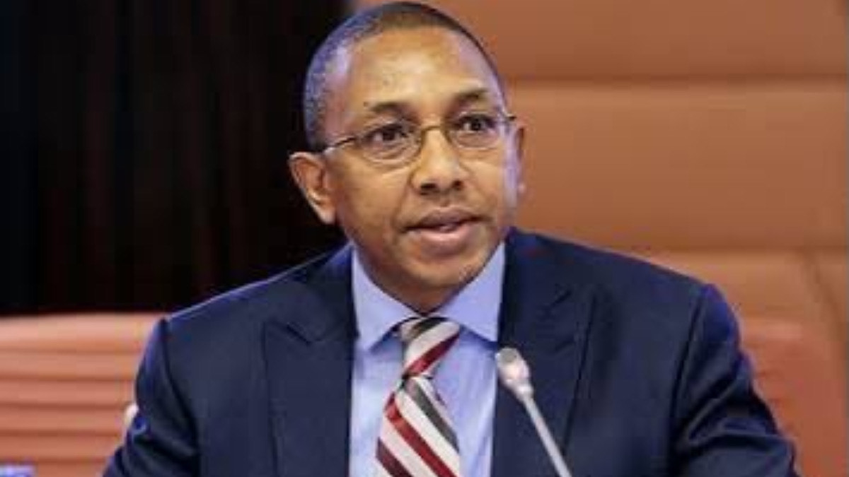 Aminu Umar-Sadiq - THEWILL NEWS MEDIA Businessman in a navy suit and striped tie speaks into a microphone during a formal meeting conference point.