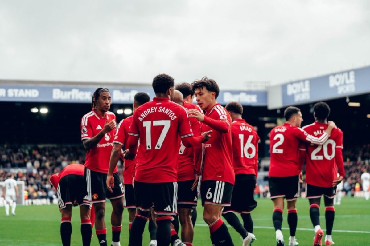 Man utd vs Leeds - THEWILL NEWS MEDIA Manchester United players in red jerseys huddle on the pitch during a match.