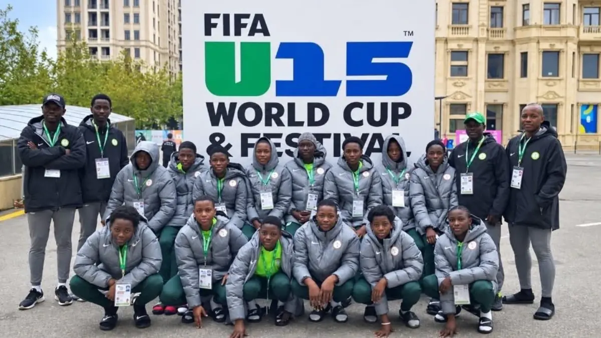 Nigerias U-15 team - THEWILL NEWS MEDIA Group of young athletes in grey jackets posing for a team photo in front of a FIFA U-15 World Cup & Festival sign