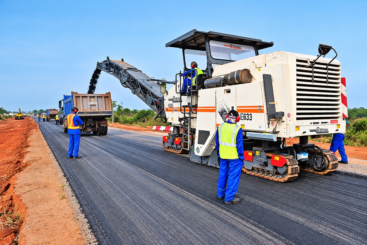 Road Project - THEWILL NEWS MEDIA Workers in high-visibility vests lay asphalt on a road using a paving machine and dump truck nearby on a sunny construction site